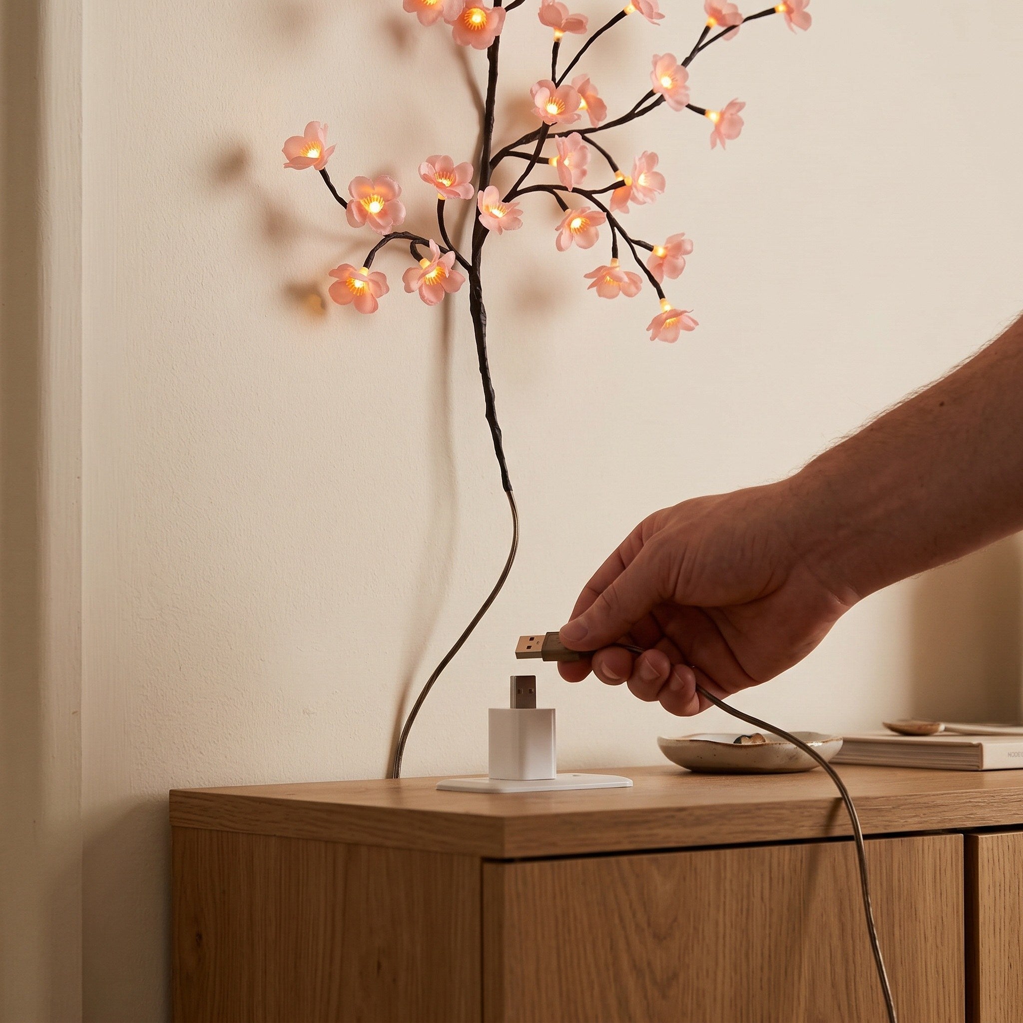 Pink blossom vine with its USB lead plugged into power