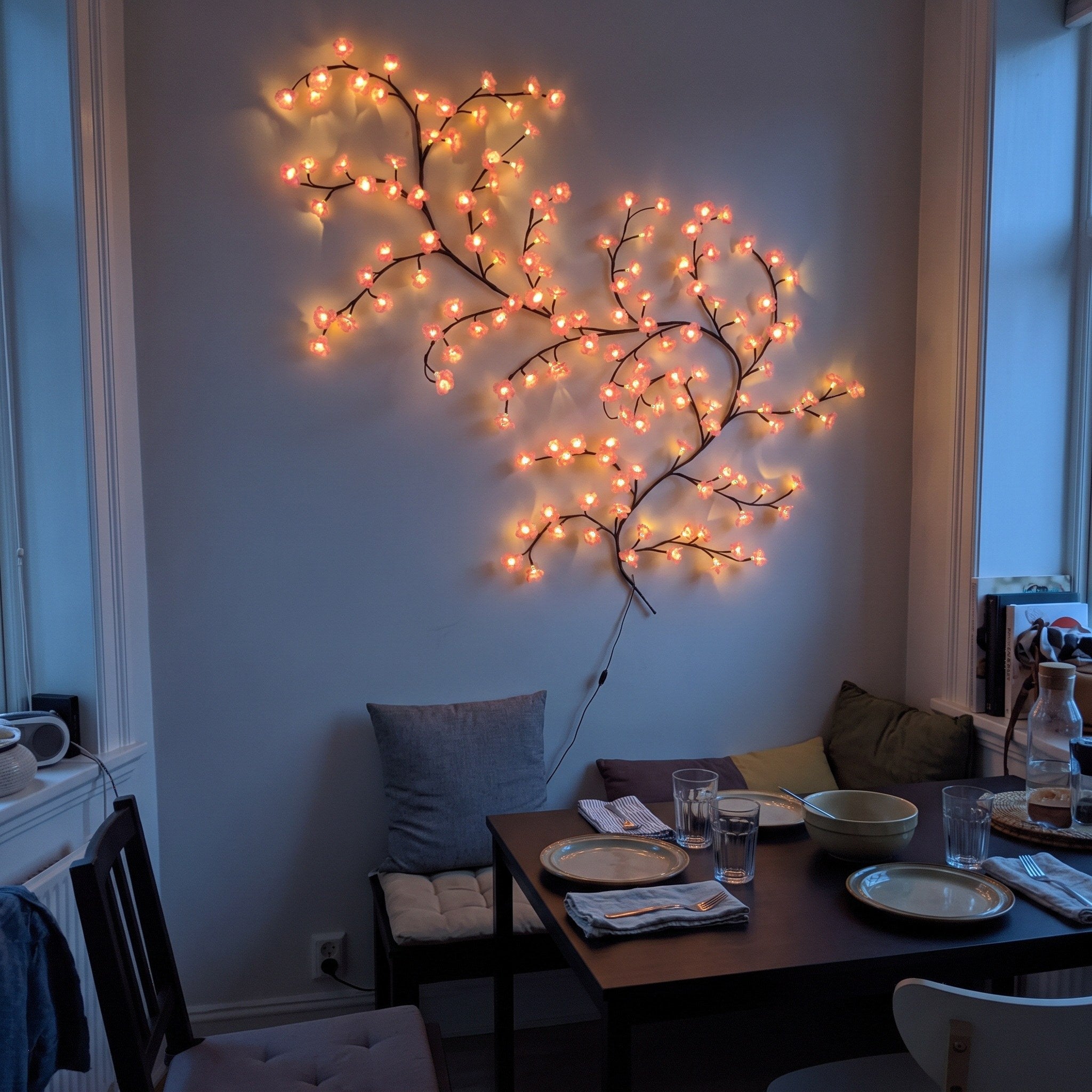 Pink blossom vine beside a dining table at dusk